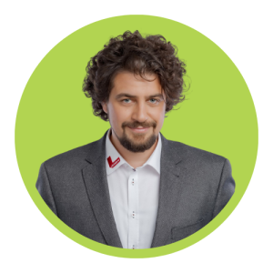 Portrait of a smiling man in a gray suit, white shirt, against a lime green circular background with a red lapel pin.