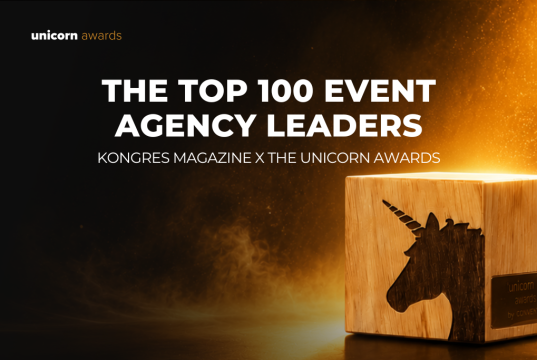 Hero banner announcing 'The Top 100 Event Agency Leaders' by Kongres Magazine x The Unicorn Awards with a glowing wooden unicorn block on the right.